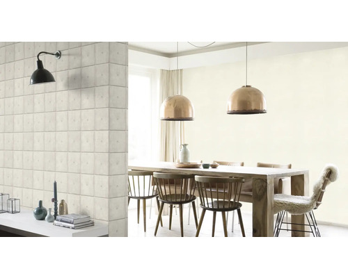 Salle à manger lumineuse avec table en bois, chaises, suspensions et un mur avec papier peint imitation pierre.