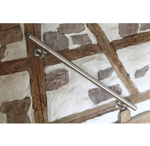 Main courante en acier inoxydable sur un mur avec ossature en bois et pierres
