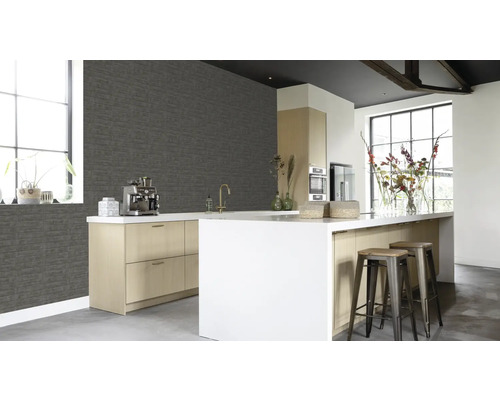 Cuisine lumineuse avec papier peint en briques grises, îlot de cuisine et tabourets de bar.