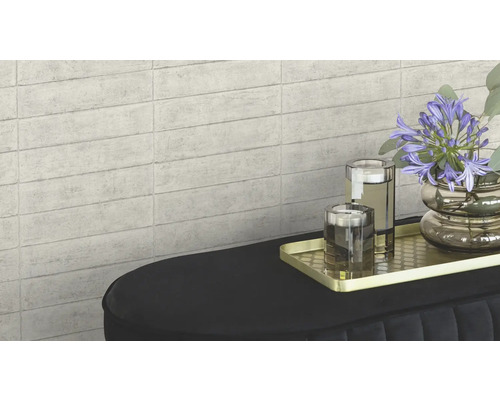 Carrelage mural aspect pierre servant de fond à une décoration sur une console.