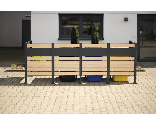 Cache-conteneurs à ordures en bois et métal devant un bâtiment