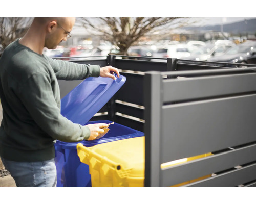 Homme ouvrant un coffre à poubelles avec deux poubelles