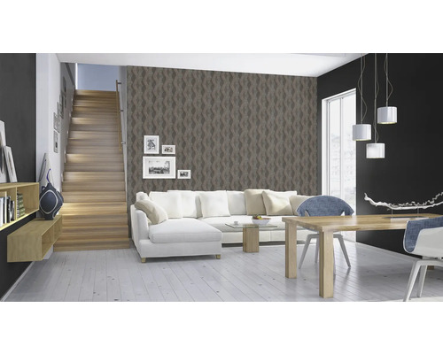 Salon avec escalier, canapé, table à manger et papier peint à motifs.