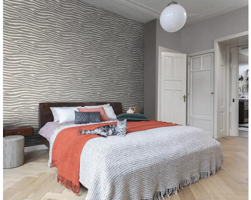 Chambre moderne avec papier peint à motifs, lit et chat