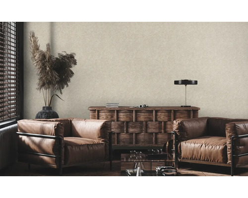 Salon avec papier peint intissé beige à structure lin, deux fauteuils en cuir et une commode en bois