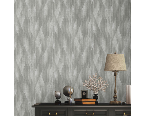 Scène avec papier peint intissé gris à motif géométrique sur un mur au-dessus d''une commode.