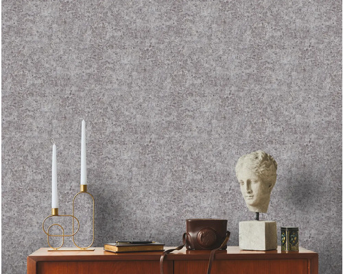 Intérieur décoratif avec papier peint à motifs, bougies, buste et appareil photo vintage sur une armoire en bois