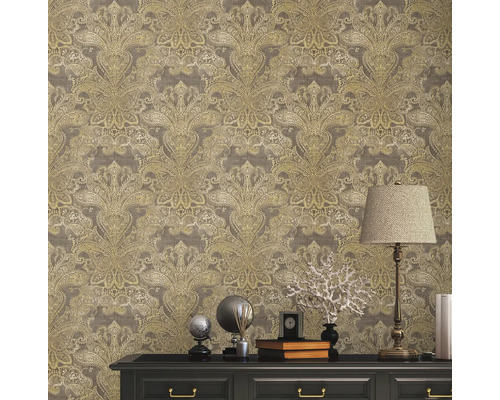 Nahaufnahme einer Wand mit floral gemusterter Tapete über einer schwarzen Kommode, die mit Dekorationsgegenständen und einer Lampe geschmückt ist.