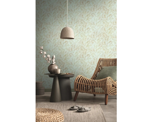 Salon avec papier peint à motifs, fauteuil en rotin et table d''appoint avec décoration