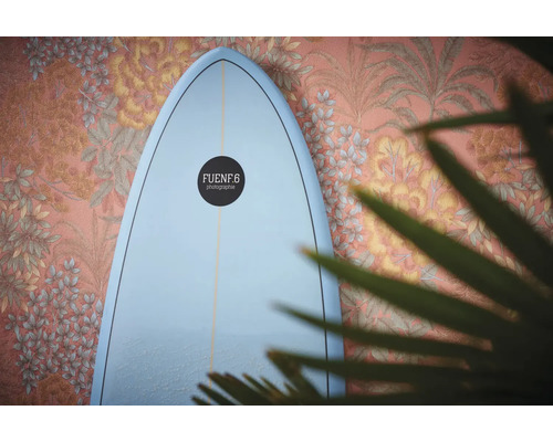 Planche de surf devant un mur avec décor floral