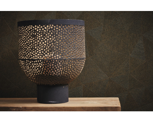 Dekorative Laterne aus Metall mit Lochmuster vor einer Wand mit geometrischem Muster