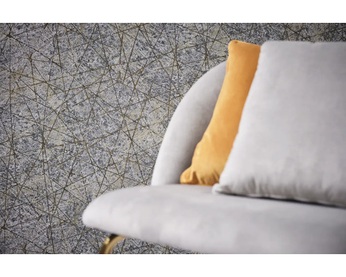 Gros plan d''un papier peint structuré gris avec un motif de lignes géométriques à côté d''un canapé avec des coussins