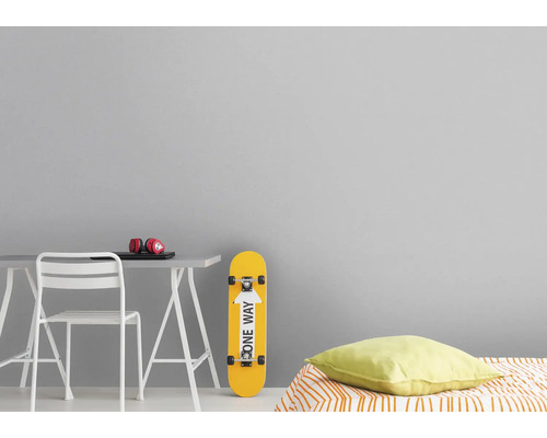 Dekoratives Zimmer mit Schreibtisch, Stuhl, Skateboard und Bett