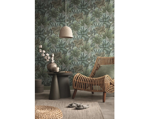 Salon avec papier peint à feuilles, fauteuil en rotin et table d''appoint