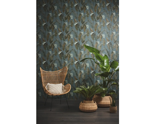 Intérieur avec fauteuil en rotin, plantes et papier peint à motif de feuilles