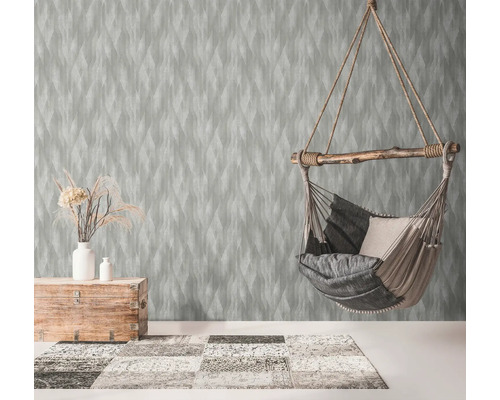 Salon avec papier peint à motifs, fauteuil suspendu et éléments en bois pour une ambiance chaleureuse