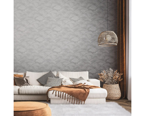 Wohnzimmer mit Sofa, Kissen, Decke, Lampe und dekorativer Wandgestaltung für eine stilvolle Atmosphäre.