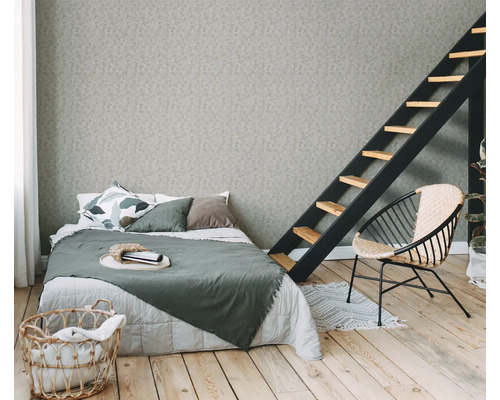 Chambre avec lit, échelle, fauteuil et panier à linge sur plancher en bois