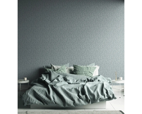 Chambre avec papier peint à motifs, lit et tables de chevet