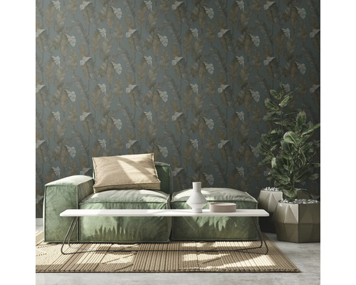 Salon avec canapé vert, table, plante en pot et papier peint à motifs floraux