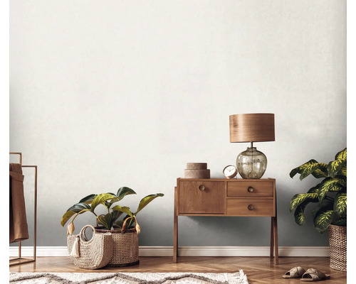 Heller Raum mit gemusterter Tapete, Kommode, Lampe und Zimmerpflanzen