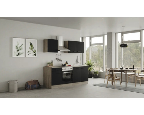 Cuisine moderne avec armoires, cuisinière, hotte et table à manger dans une pièce lumineuse.