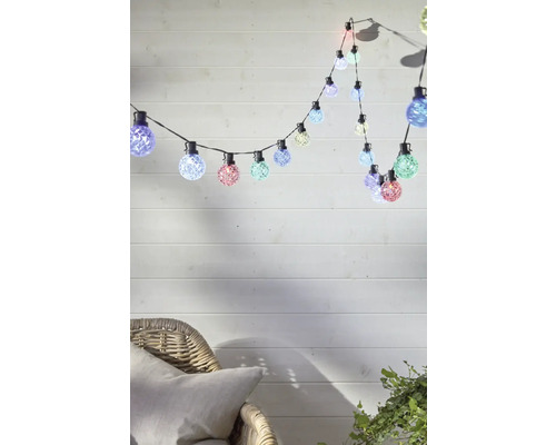 Lichterkette mit mehrfarbigen Leuchtmitteln über einem Stuhl