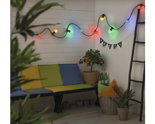 Szene mit einer Lichterkette, einer Bank, Pflanzen und einer Leiter für eine helle, organisierte Gartendekoration.