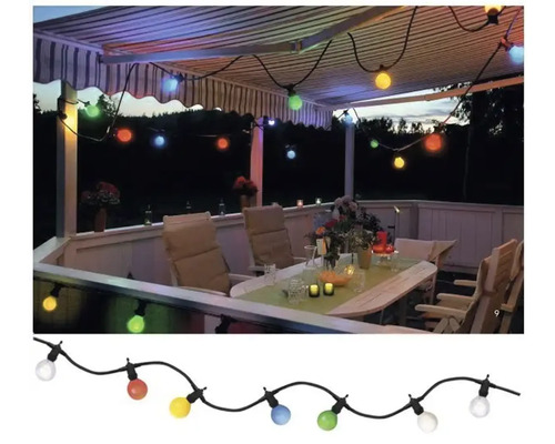 Terrasse mit beleuchteter Lichterkette und Gartenmöbeln