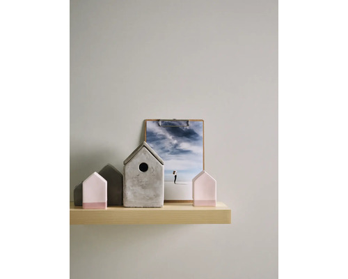 Maisons décoratives en béton et en bois sur une étagère avec une photographie.