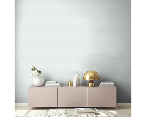 Pièce décorée avec papier peint de couleur claire et commode avec objets de décoration.