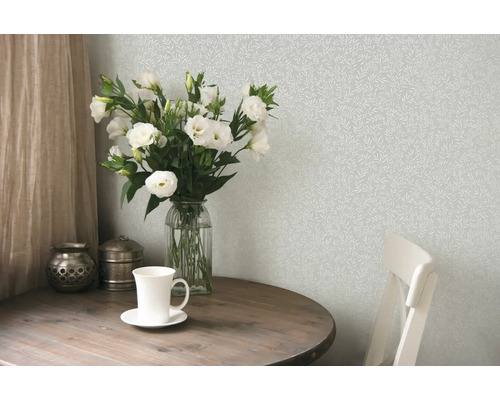 Szene mit gemusterten Tapeten, Blumenstrauß und Holztisch