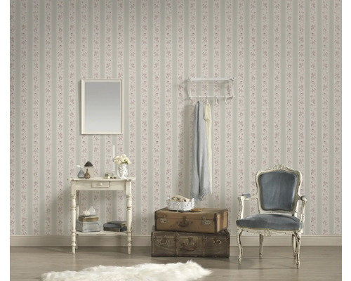 Pièce décorative avec papier peint à fleurs rayé, miroir, table, porte-manteau, fauteuil et valises