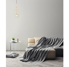 Salon avec canapé, couverture, table et lampe