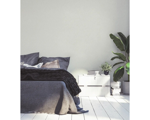 Helles Schlafzimmer mit Bett, Nachttisch und Zimmerpflanzen