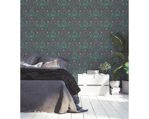 Schlafzimmer mit Blumentapete, Bett, Kommode und Zimmerpflanze