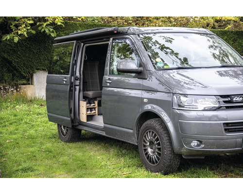 Van gris avec porte coulissante ouverte et étagère à chaussures à l''intérieur.