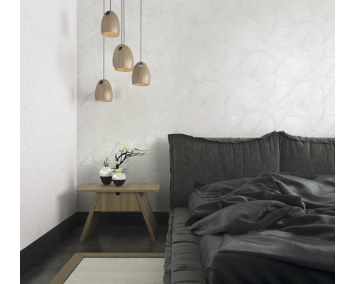 Chambre avec lit, table de chevet, lampe et papier peint à motifs