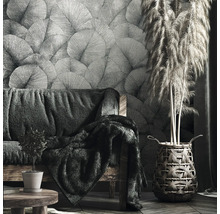 Salon avec papier peint à motifs, canapé et herbe décorative dans un panier