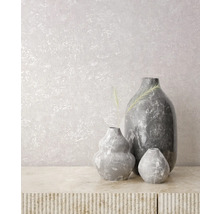 Vases gris décoratifs sur une table texturée devant un mur.