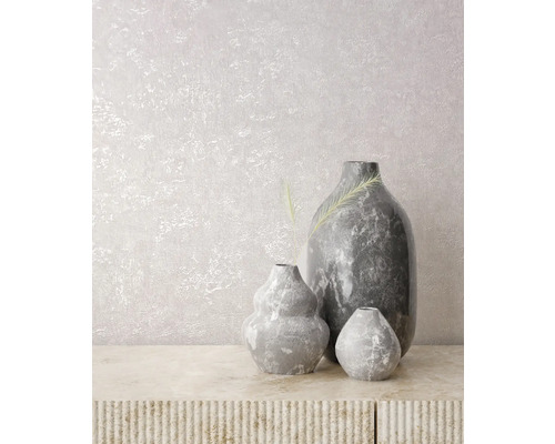 Vases gris décoratifs sur une table texturée devant un mur.
