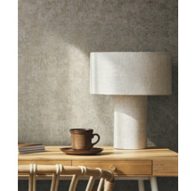 Scène avec bureau, lampe de table, tasse et carnets devant un mur texturé