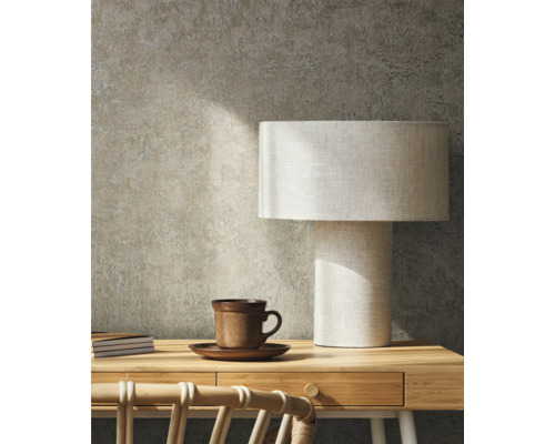 Scène avec bureau, lampe de table, tasse et carnets devant un mur texturé