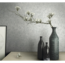 Nature morte décorative avec des vases et des fleurs artificielles sur une table.