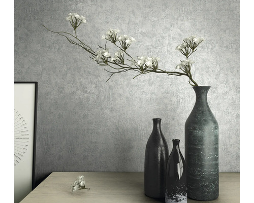 Nature morte décorative avec des vases et des fleurs artificielles sur une table.