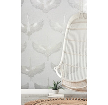 Scène avec un dispositif de suspension blanc devant un papier peint à motif de grue.