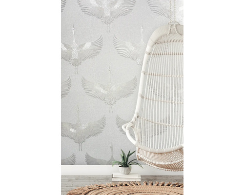 Scène avec un dispositif de suspension blanc devant un papier peint à motif de grue.