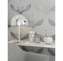 Gros plan d''une pièce avec une lampe, des vases et du papier peint à motifs.