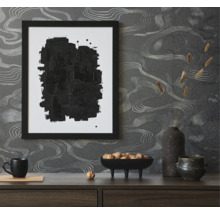 Scène décorative avec image encadrée noire, bol de noix et papier peint abstrait