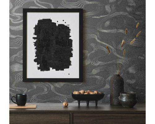 Scène décorative avec image encadrée noire, bol de noix et papier peint abstrait